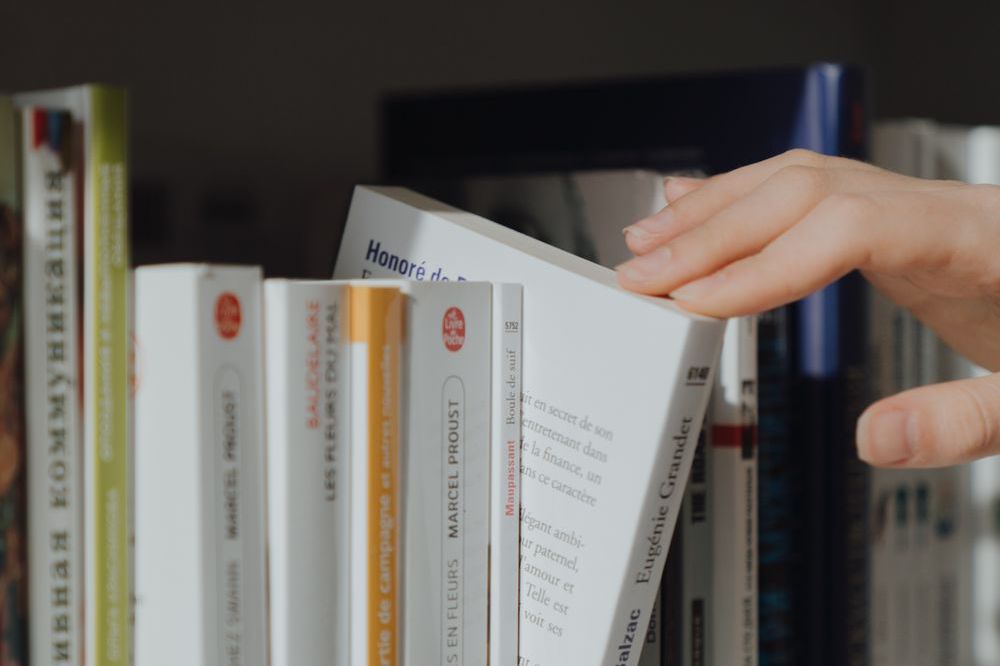 書棚から本を取り出す手