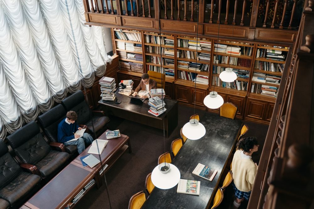 書棚に囲まれた図書室で学ぶ人